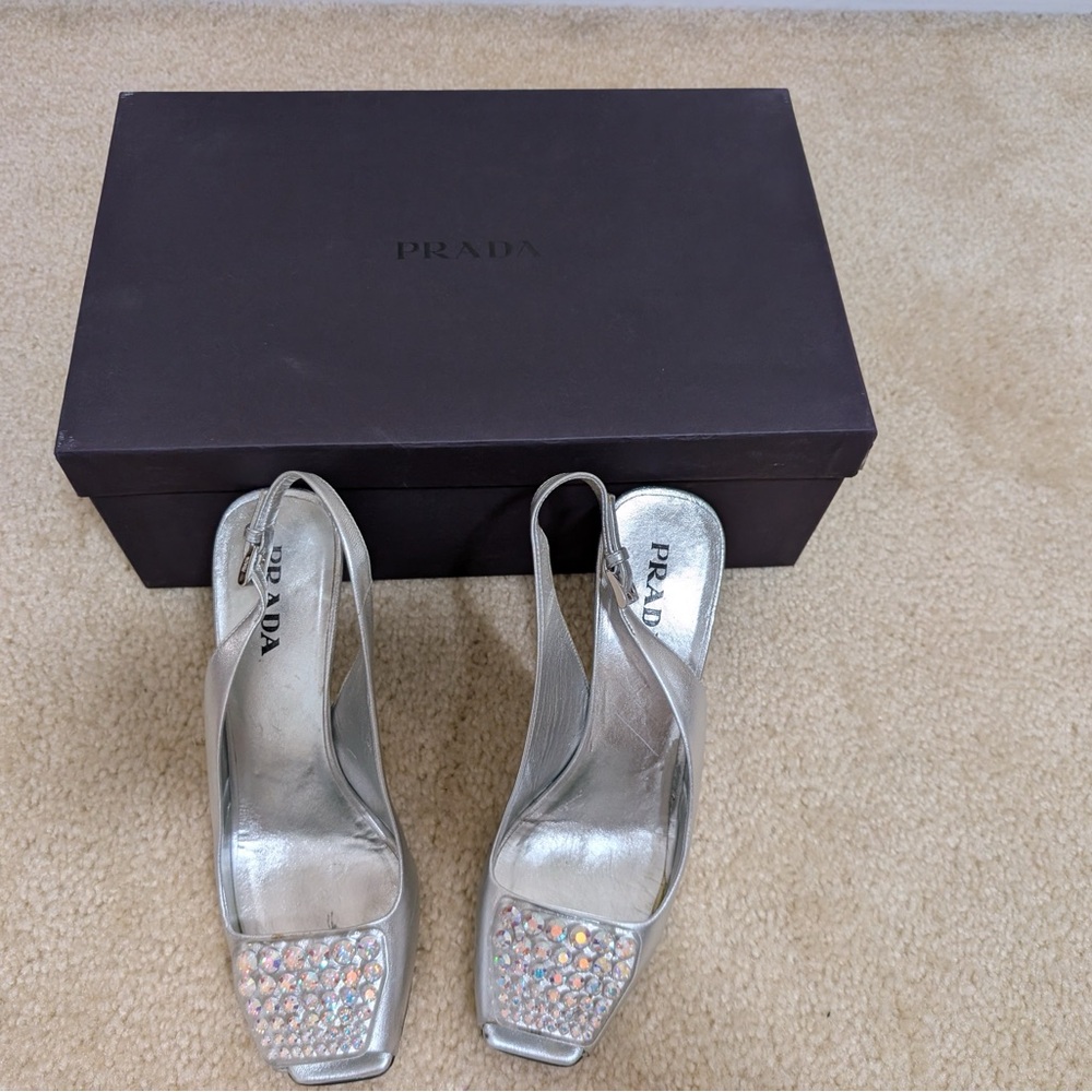 Prada silver leathers size 8 sling back heel with rhinestone embelishment.